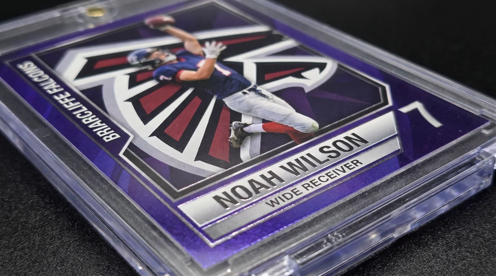 Close-up of a custom football trading card's foil border inside its magnetic case