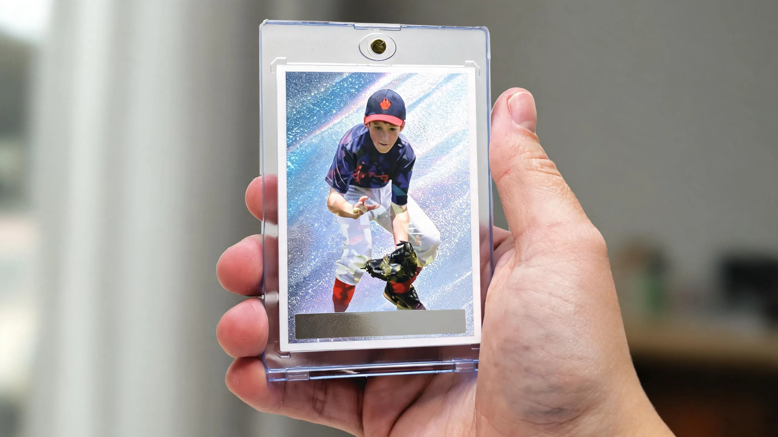Hand holding custom ccg cards in a magnetic case, icy blue refractor athlete design.