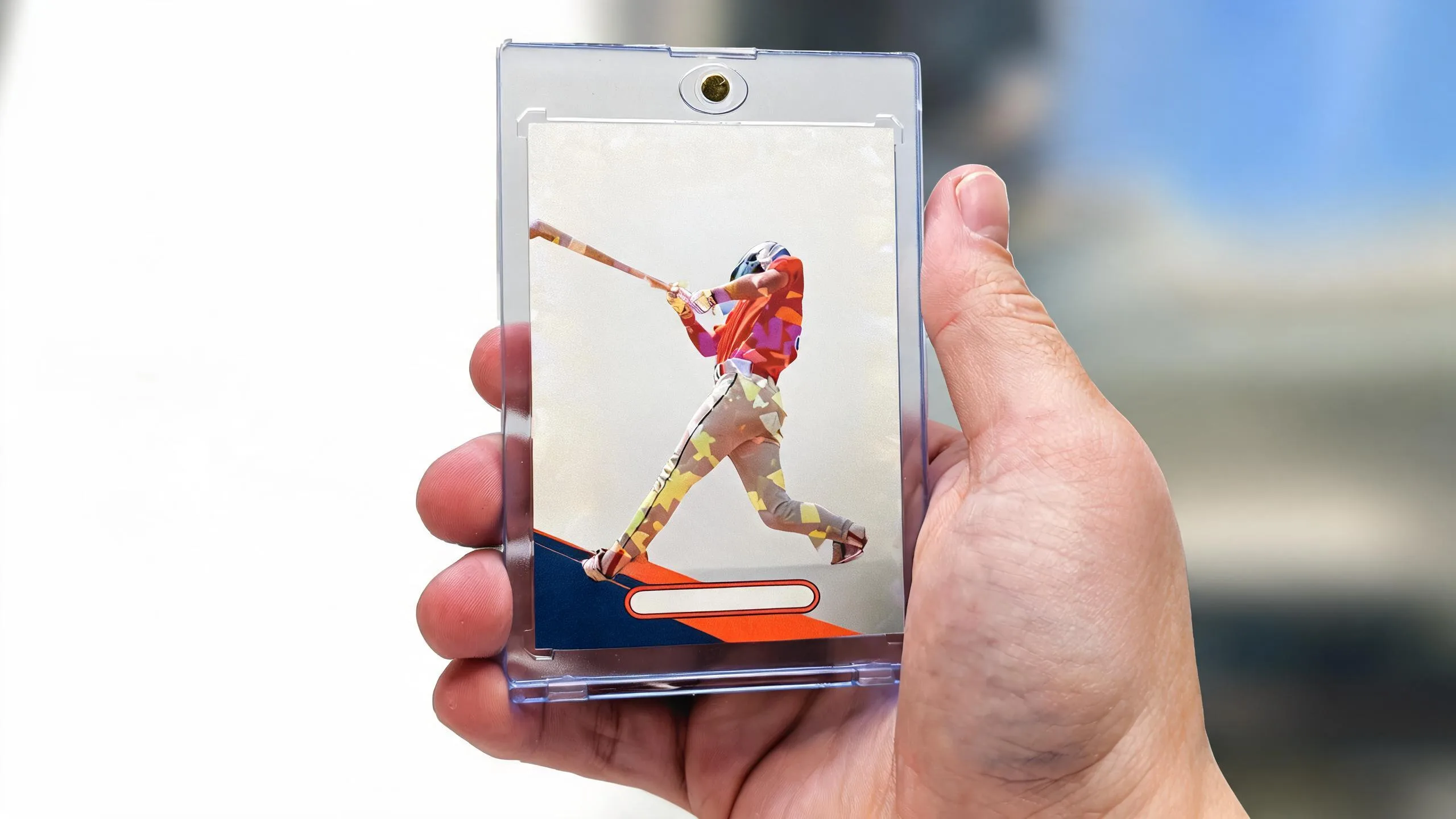 Hand holding a design card design trading card in a clear magnetic acrylic case outdoors