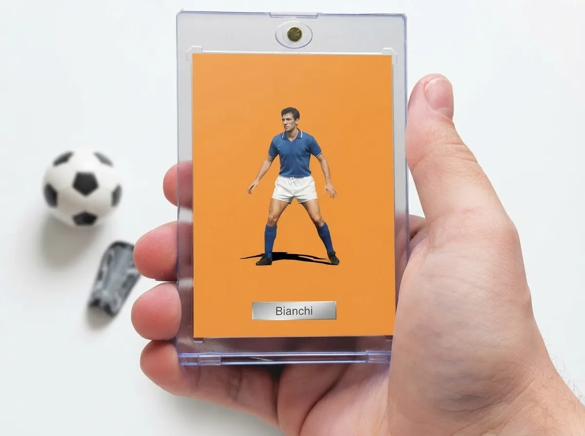 Hand holds magnetic case with orange editorial custom soccer trading card, ball and shin guard nearby.