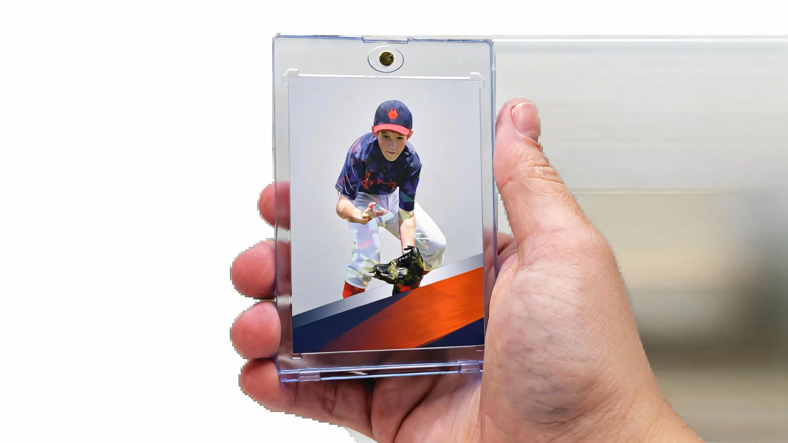 Hand holding a magnetic case with a custom sports card — make your own sports card design.