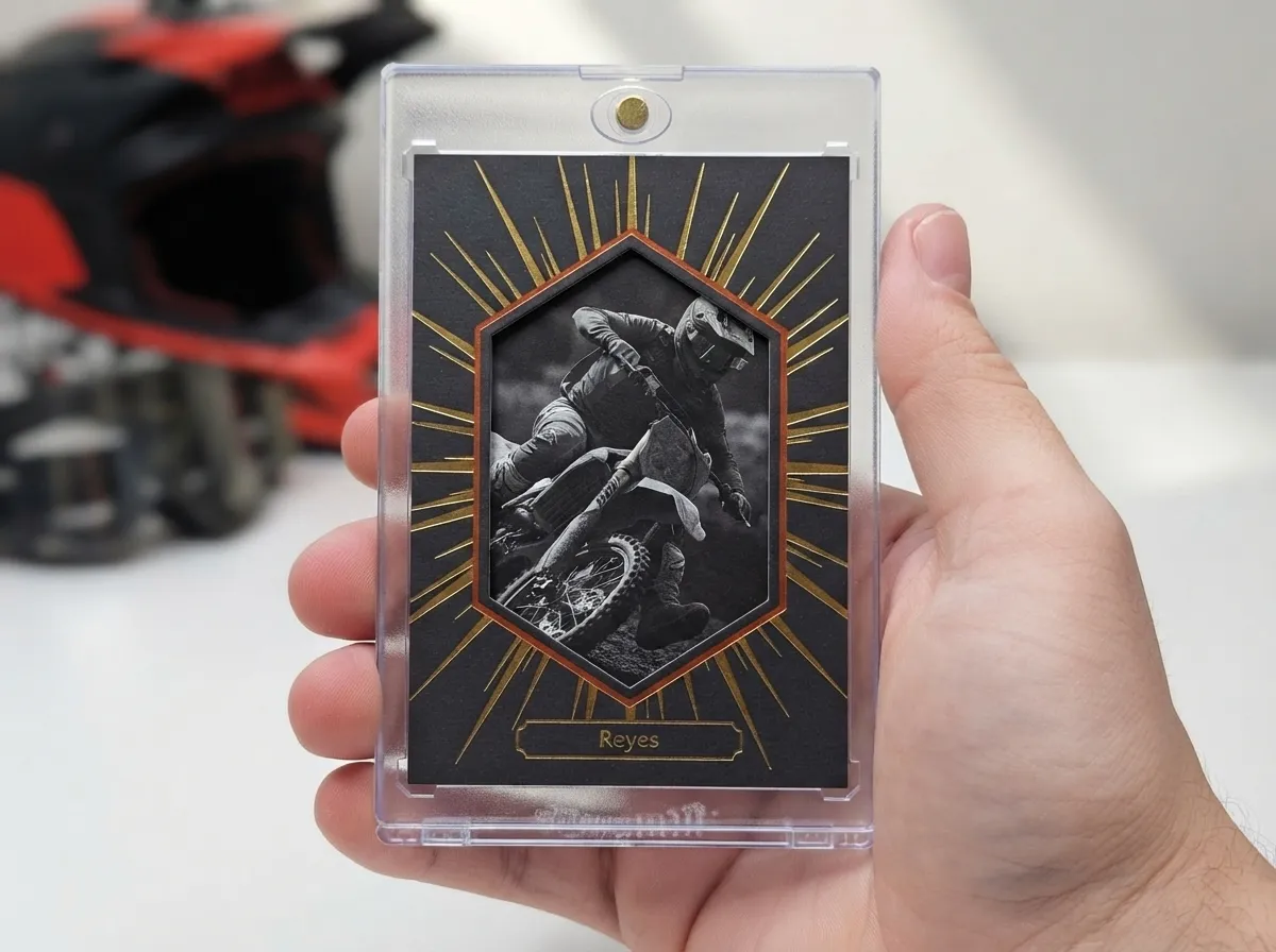 Magnetic case holding gold foil motocross trading card with die-cut spotlight design.
