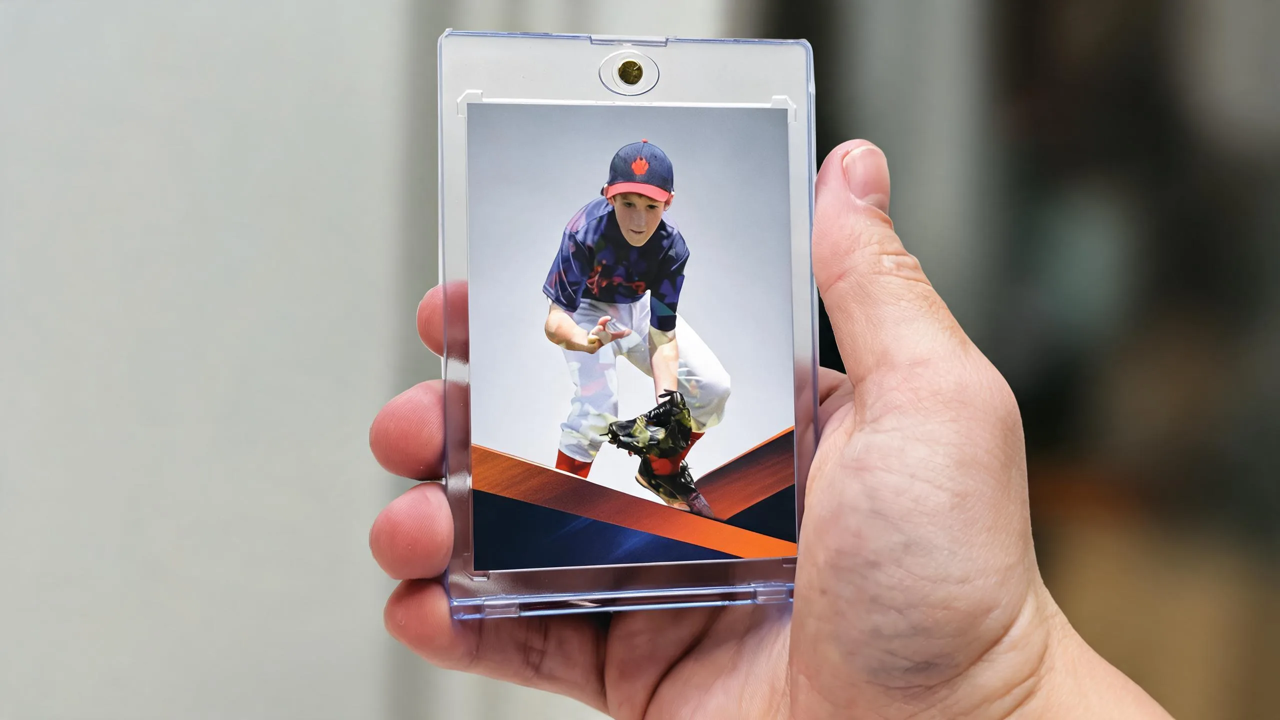 Hand holding magnetic case with new sports card releases featuring a bold action-pose athlete card.