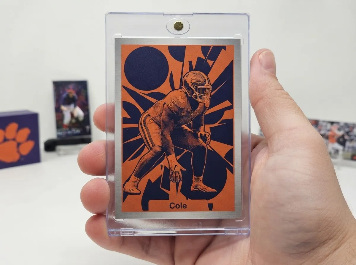 Custom football trading card in magnetic case, orange and navy duotone poster design on white tabletop.