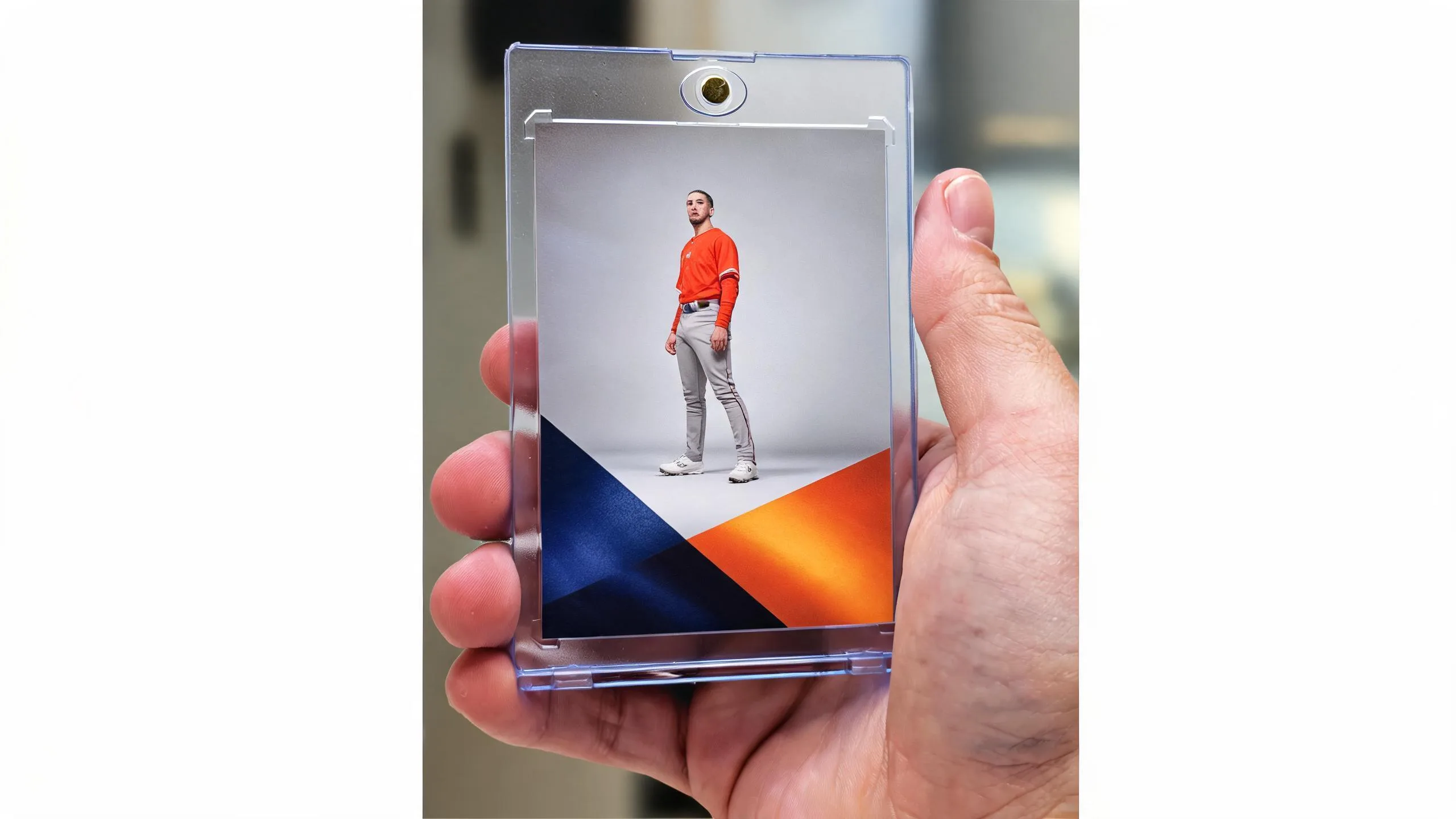 Hand holding a magnetic case showing what are the dimensions of a trading card, portrait keepsake design.