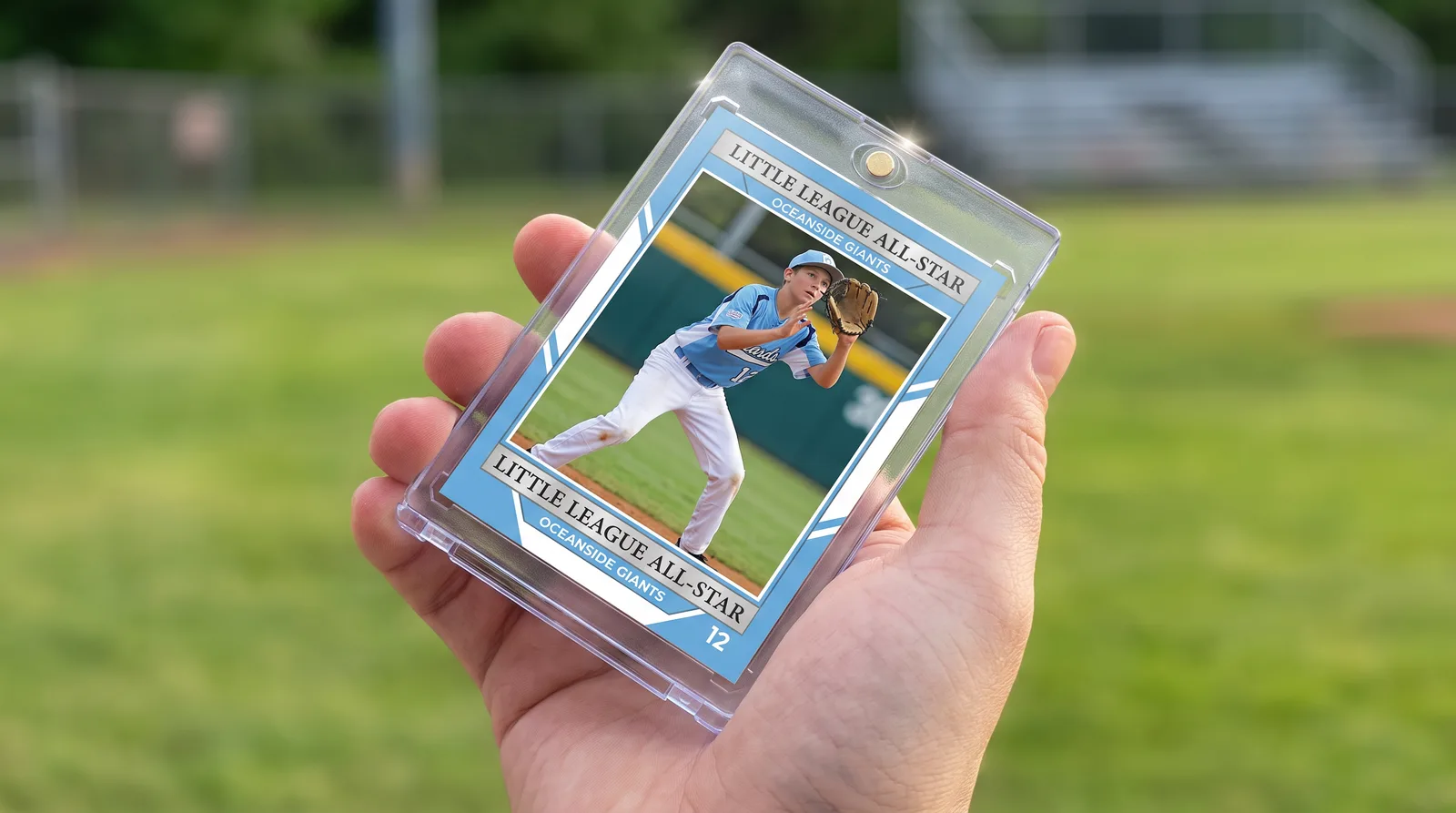 Custom little league baseball trading card held in its magnetic case in front of a blurred playing field